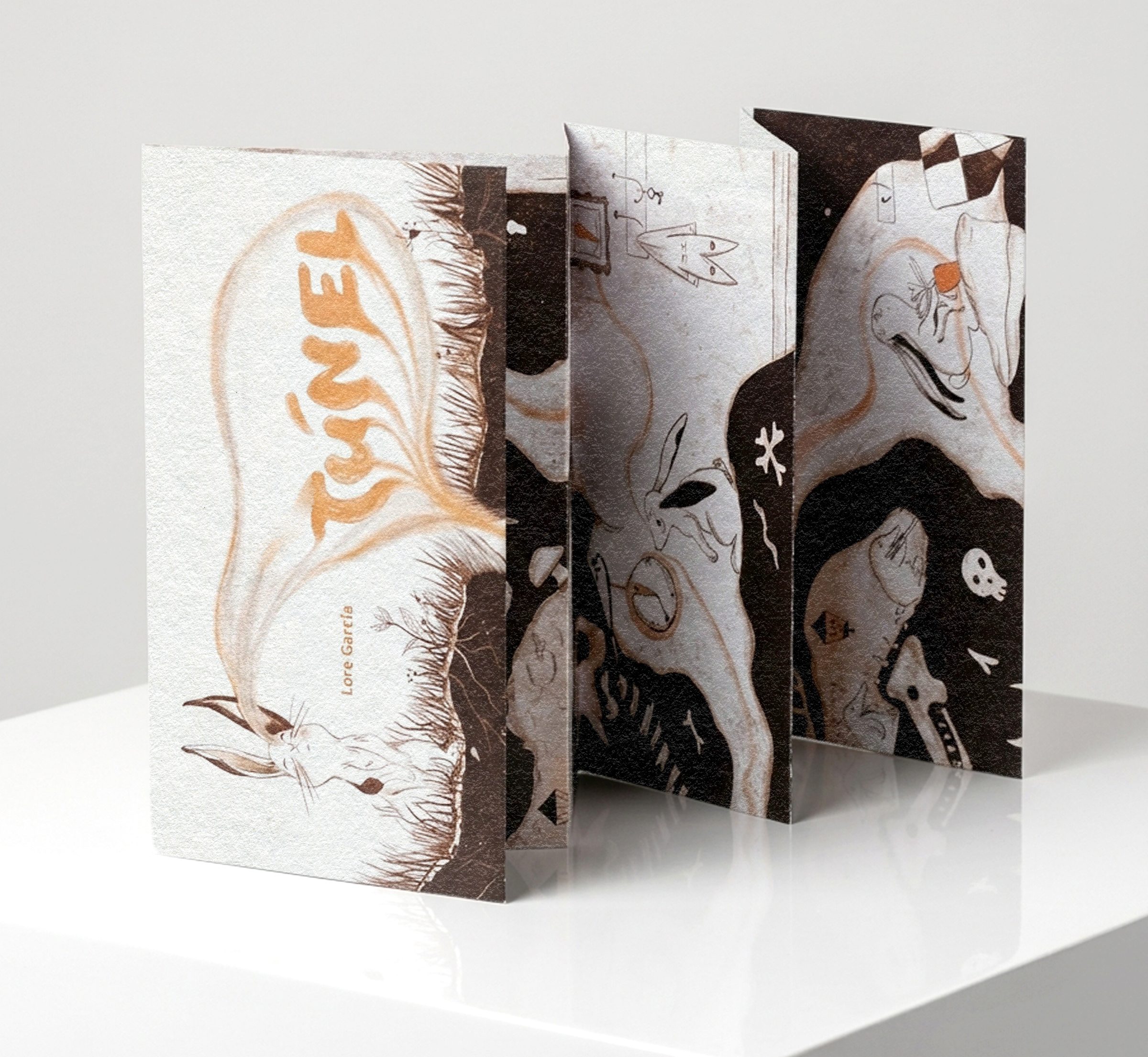 Mockup of the accordion book standing half-unfolded on a white table, with the cover showing a rabbit and the title Túnel